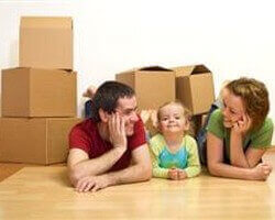 זוג צעיר עם ילד בדירה חדשה וקרטונים מסביב